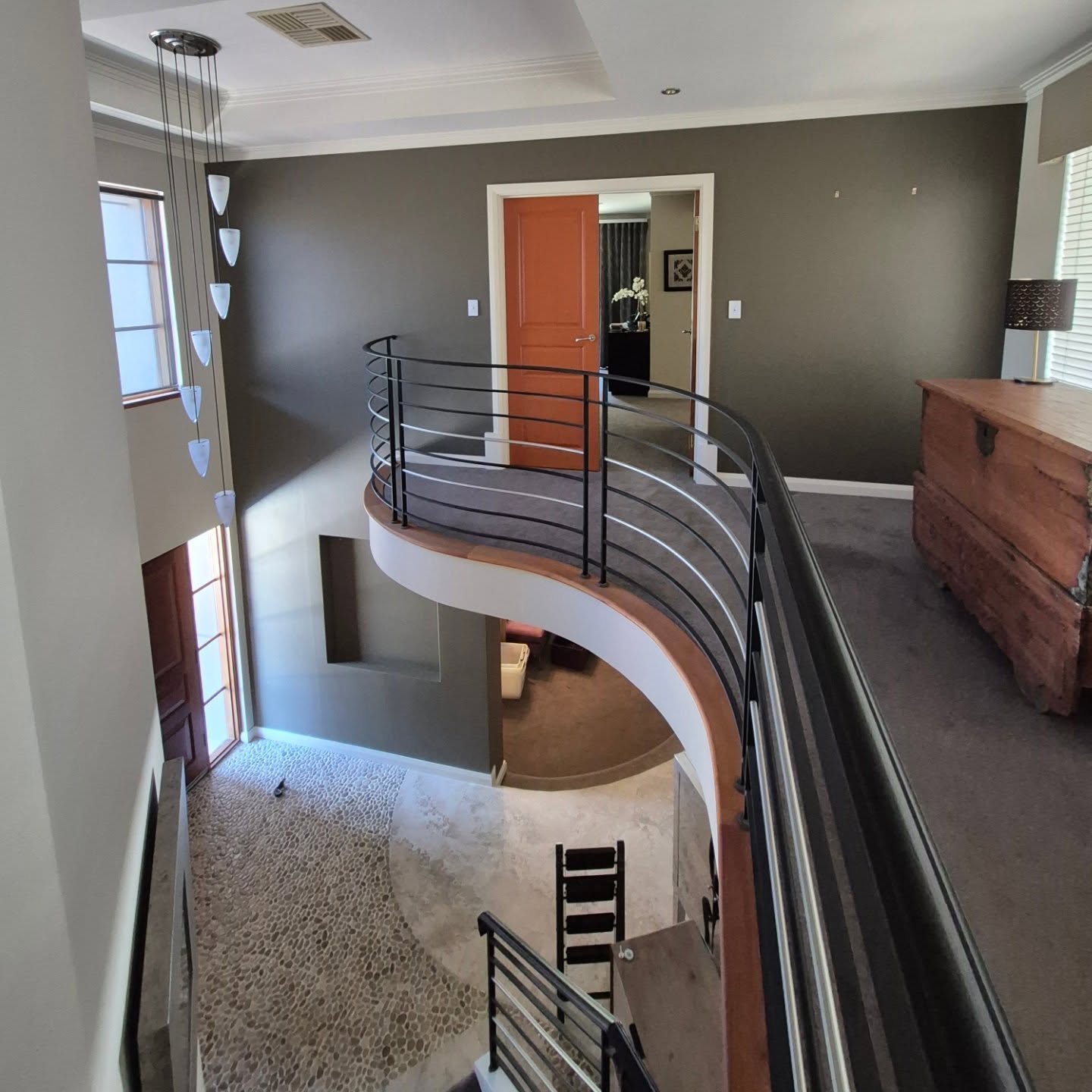 Sophisticated curved staircase interior with dark feature walls